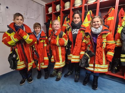 Die Grundschulkinder in den schweren Einsatzjacken